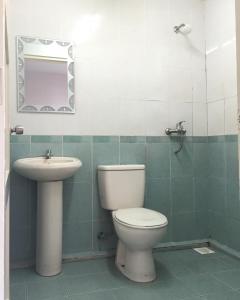 a bathroom with a toilet and a sink and a mirror at Raja Inn in Miri