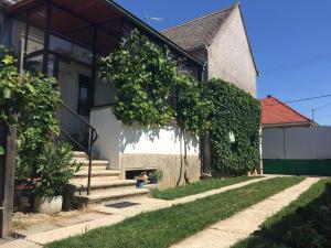 uma casa com um cão sentado no alpendre da frente em Green Garden House em Gencsapáti