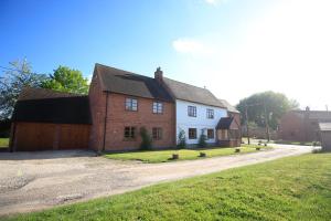 uma casa branca e vermelha com garagem em Three Ways Farmhouse B&B em Stratford-upon-Avon