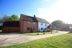 a white and red house with a garage at Three Ways Farmhouse B&B in Stratford-upon-Avon