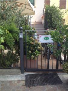 a black iron gate with a sign on it at Affittacamere Porticciolo in Castelnuovo del Garda