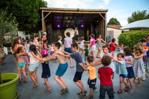 un gruppo di bambini che ballano di fronte alla folla di Camping Les Peupliers a La Flotte