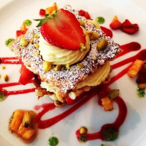 een witte plaat met een dessert met een aardbei erop bij Cors'Hotel in Biguglia