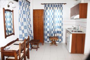 a kitchen with a table and chairs and a kitchen with a sink at Villa Kriezi in Spetses