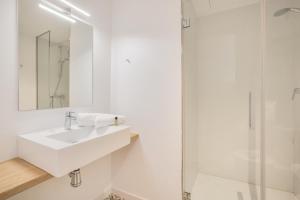 a white bathroom with a sink and a shower at Flateli Plaça Catalunya 1.1 in Girona +12 photos