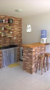 a kitchen with a counter and some stools in it at O Pouso Condomínio in Mucugê