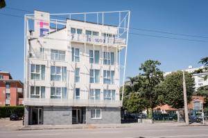 a tall white building with a reflection in the window at MyPlace Padova Ospedale in Padova