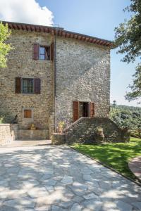 una vista esterna di una casa in pietra con vialetto di Il Castello di Rigutinelli ad Arezzo