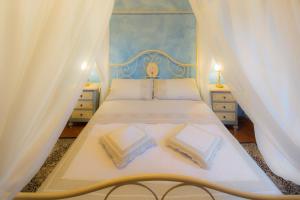 una camera con letto a baldacchino blu e bianco di Il Castello di Rigutinelli ad Arezzo
