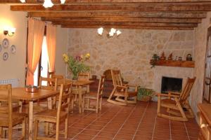 a dining room with tables and chairs and a fireplace at Casa Rural Blas in Brihuega