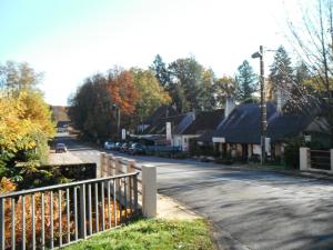 a street in a small town with a fence at Maison de L`Etang in Tronçais