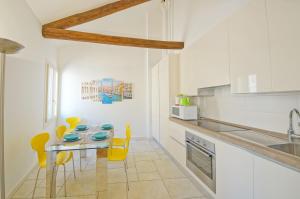 een keuken met een tafel en gele stoelen bij DolceVita Apartments N 394 in Venetië