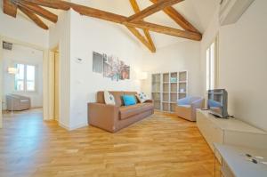 een woonkamer met een bank en een tv bij DolceVita Apartments N 394 in Venetië