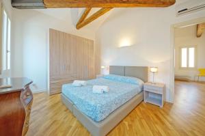 een grote slaapkamer met 2 bedden en een houten vloer bij DolceVita Apartments N 394 in Venetië