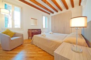 a bedroom with a bed and a chair and a table at DolceVita Apartments N 393 in Venice