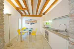 a kitchen with a dining table and yellow chairs at DolceVita Apartments N 393 in Venice