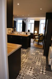 a kitchen with black cabinets and a living room at L'archipel in Lille