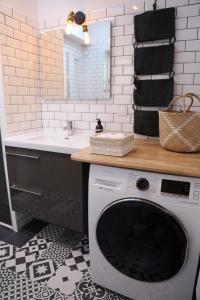uma máquina de lavar roupa na casa de banho com um lavatório em L'archipel em Lille
