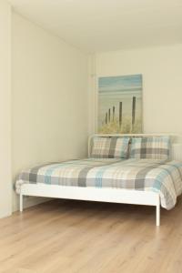 białe łóżko w pokoju z oknem w obiekcie Apartment Boven Jan 574 w mieście Den Helder
