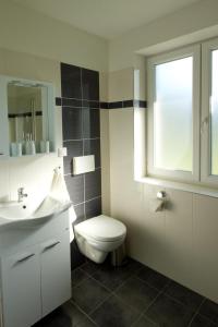 La salle de bains est pourvue de toilettes, d'un lavabo et d'une fenêtre. dans l'établissement Chalupa pod Hruškou, à Zubří
