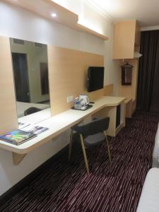 um quarto de hotel com uma secretária e um espelho em RHR Hotel Kajang em Kajang