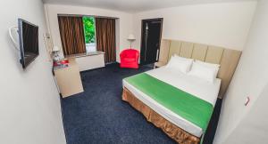 Pokój hotelowy z łóżkiem i czerwonym krzesłem w obiekcie Hotel Anapa Okean w mieście Anapa