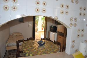 a dining room with a table and a bedroom at la brezza in Marzamemi