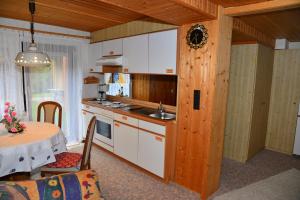 a kitchen with a table and a kitchen with white cabinets at Pension Mausbachtal in Warmensteinach