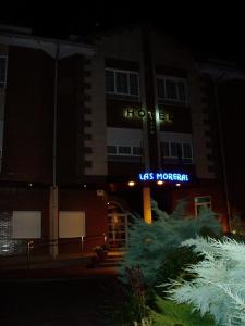 a building with a lit up sign in front of it at Hotel Las Moreras in León