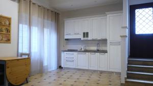 ローマにあるEleonora's Apartmentの白いキャビネットと窓付きの白いキッチン