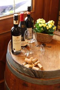 ein Fass mit drei Flaschen Wein und Weingläsern in der Unterkunft Hotel Ickhorn in Werne an der Lippe