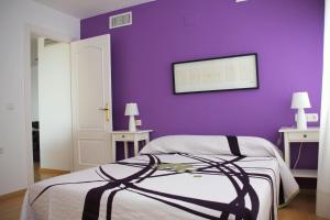 - une chambre avec un mur violet et un lit dans l'établissement Apartamento Playamar 16, à Torremolinos