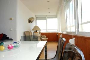 sala de estar con mesa blanca y sillas en Apartamento Playamar 16, en Torremolinos