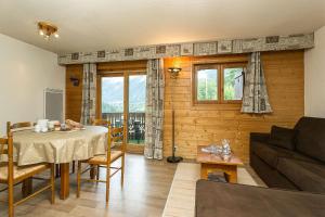 un salon avec une table et un canapé dans l'établissement APARTMENT REFUGE DE BELLACHAT - Alpes Travel - Les Houches - Sleeps 4, aux Houches 7 autres photos