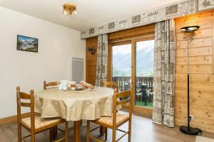 レ・ズッシュにあるAPARTMENT REFUGE DE BELLACHAT - Alpes Travel - Les Houches - Sleeps 4のダイニングルーム(テーブル、椅子、窓付)