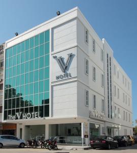 a large white building with a large clock on it at The V Hotel in Kuantan