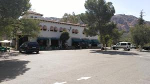 a building with cars parked in a parking lot at Venta Las Delicias in Villanueva del Rosario