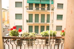 een balkon met rode bloemen op een gebouw bij Casa di Gina in Verona