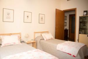 een slaapkamer met 2 bedden en een boekenplank bij Casa di Gina in Verona