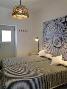 een slaapkamer met een bed met een zwart-wit gestreepte deken bij Mike'sPlace in Antiparos Stad