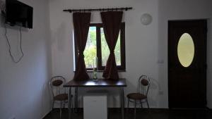 a room with a table and chairs and a window at Casutele Andreica in Vişeu de Sus