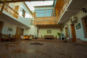 an empty courtyard with tables and chairs in a building at Hotel Nasriddin Navruz in Bukhara