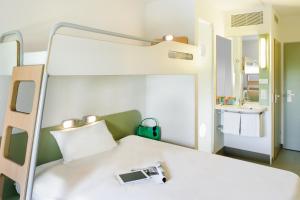 a bedroom with a bunk bed with a camera on it at Felix Hotel Darmstadt in Darmstadt