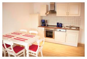 una cocina con mesa blanca y sillas. en PETITE FRANCE Apartment - EP Ticket Garantie, en Rust