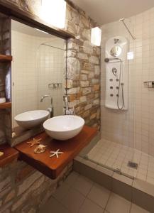 La salle de bains est pourvue de 2 lavabos et d'une douche. dans l'établissement Adis Oneirou, à Mouresi