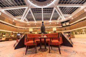 a lobby with a table and chairs in a building at Hotel Grand Swiss in Erbil