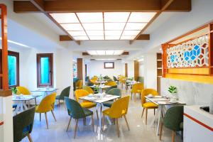 a dining room with tables and yellow chairs at Atrium Ambiance Hotel in Rethymno Town