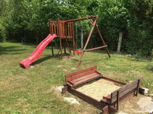 a playground with a red slide and a swing at Willa Baśka in Chańcza