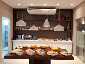 uma cozinha com uma mesa com tigelas de comida em Ventura Hotel em Barreiras