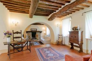 a living room with a table and a fireplace at Agriturismo Le Macchie in Monticchiello